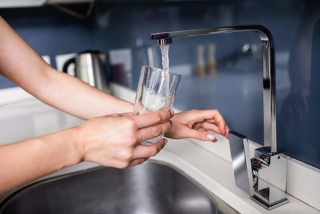 Person Filling Glass of Water