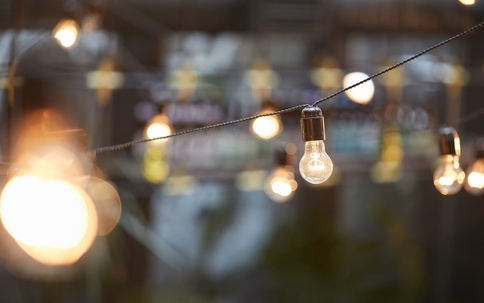 String of warm-light bulbs hanging on a dark string. Out of focus background.