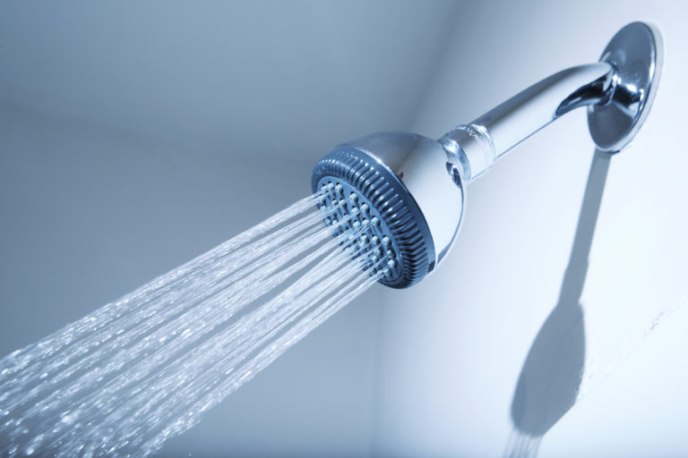 A shower head with water spraying.